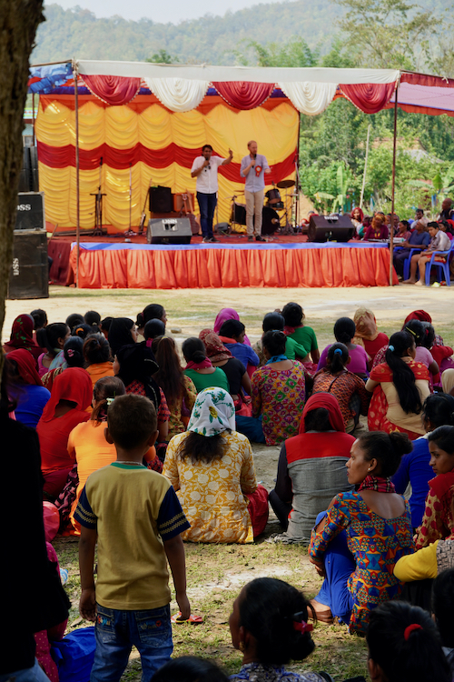 Missionary fundraiser Brent Earwicker preaches from a stage in Nepal.